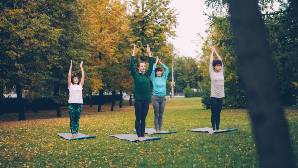 Women stretching and practising yoga in the park, supporting joint health through an active lifestyle