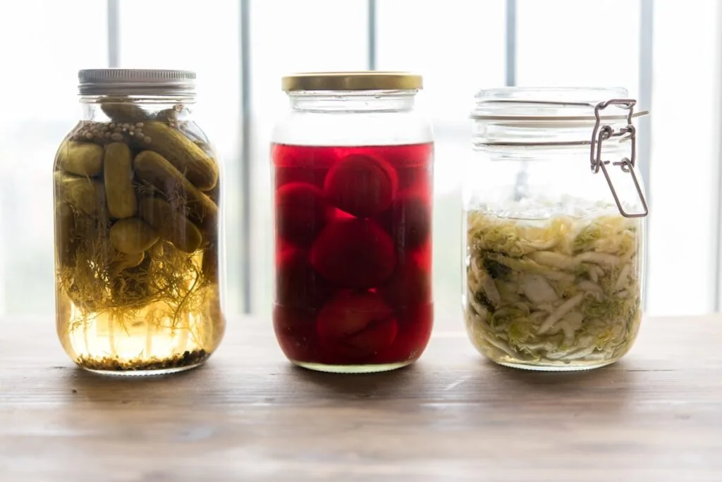 Three jars filled with different types of fermented food, supporting digestive health
